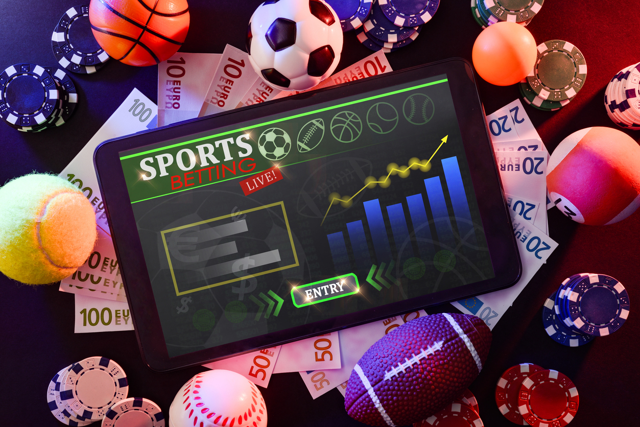 Live sports betting dashboard on a tablet with chips and currency
